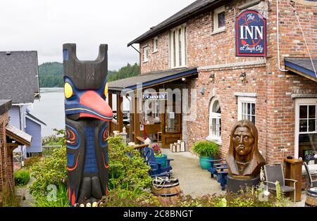 Esterno dell'Inn at Tough City nella città di Tofino, British Columbia, Canada. Totem pole e sculture indigene fuori dall'hotel. Foto Stock