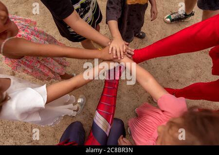 Gruppo di bambini che si accatastano le mani insieme Foto Stock