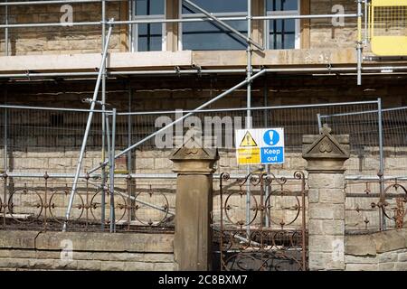 Un avviso DA TENERE AL Centro di Educazione per gli adulti di New Mills, Derbyshire, dove sono in corso lavori di costruzione. Foto Stock