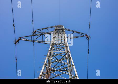 Potenza di trasmissione dell'elettricità. Torre ad alta tensione con fili su sfondo sfocato. Energia industriale Foto Stock