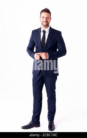 Foto a lunghezza intera di bel uomo d'affari che indossa il vestito mentre si trova su uno sfondo bianco isolato. Foto Stock