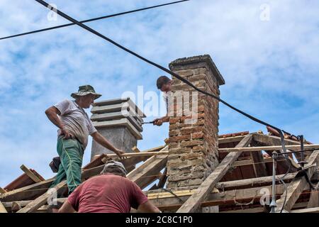 Zrenjanin, Serbia, 22 luglio 2020. Un gruppo di maestri sta lavorando sul tetto di una casa privata per sostituire una vecchia piastrella. Usano una bella giornata e stabile Foto Stock