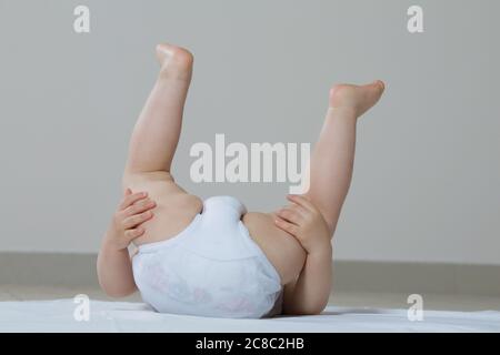 Ragazza del bambino che gioca sul pavimento capovolto-giù Foto Stock