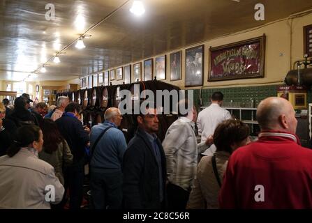 Malaga, Andalusia / Spagna / Aprile 12 2016 : la gente gusta il vino locale di Malaga in un bar vecchio stile nel centro della città. Le botti allineano le pareti, Foto Stock