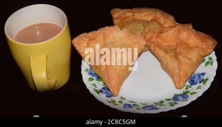 Spuntini Indiani Samosa con te' caldo Foto Stock