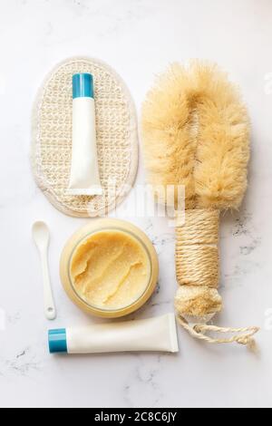 Composizione Spa. Prodotti ecologici. Cosmetici per la cura della pelle. Lozione, olio per il corpo, maschera, sale da bagno, sapone fatto a mano, spazzola di bambù su un tavolo di marmo bianco Foto Stock