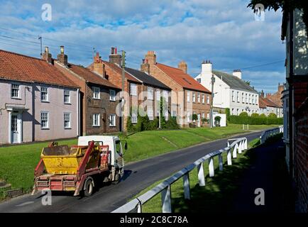 Camion che trasportano il salto di spazzatura, nel villaggio di Stillington, nel Nord Yorkshire, Inghilterra Regno Unito Foto Stock