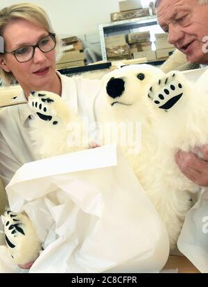 23 luglio 2020, Sassonia-Anhalt, Bad Kösen: Direttore generale Costanza Schache e portavoce della società Dr. Helmut Schache confezionano un orso polare di mohair peluche di 85 centimetri in un pacchetto presso la Bad Kösener Spielzeug Manufaktur GmbH. Il piccolo orso polare di peluche bianco-neve con numero 1 inizia il suo viaggio verso l'attivista svedese per la protezione ambientale Thunberg. Il giocattolo è fatto di mohair ecologico su cotone, ha artigli fatti di feltro e una vita interna riutilizzabile. È inteso come un piccolo segno di gratitudine a Greta, 17 anni, che sta attirando l'attenzione mondiale per lui Foto Stock