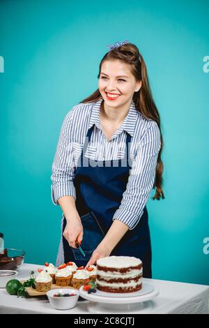 Donna felice in blusa spogliata decorazione torta deliziosa Foto Stock