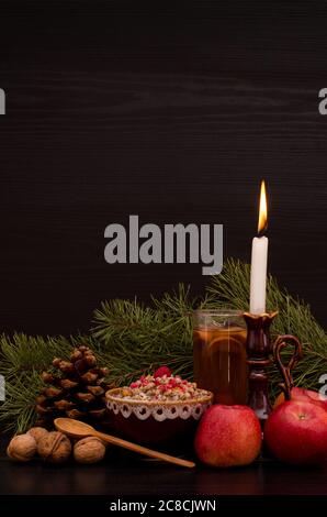 Kutia piatto tradizionale di Natale tra gli Slavi. Candela, mele, bevande e pino Foto Stock