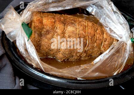 Maiale appena sfornato in spezie in una manica per tostare, solo con un forno su una teglia. Foto Stock