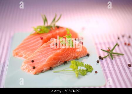 filetto di salmone crudo, pesce crudo, pepe e erbe aromatiche Foto Stock