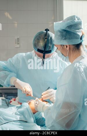 Un altro intervento chirurgico. Team medico chirurgico che opera in una sala chirurgica del chirurgo maturo ospedale che conduce un occup professionale di professione di operazione Foto Stock