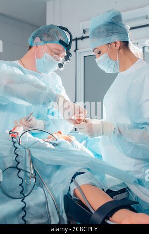 Un altro intervento chirurgico. Team medico chirurgico che opera in una sala chirurgica del chirurgo maturo ospedale che conduce un occup professionale di professione di operazione Foto Stock