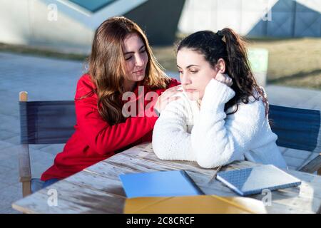 Una donna teenage che conforta un'altra dopo la rottura in su Foto Stock