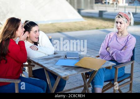 Due amici pettegolezzi criticando un'altra donna all'aperto Foto Stock