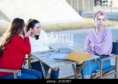 Due amici pettegolezzi criticando un'altra donna all'aperto Foto Stock