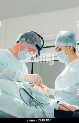 Un altro intervento chirurgico. Team medico chirurgico che opera in una sala chirurgica del chirurgo maturo ospedale che conduce un occup professionale di professione di operazione Foto Stock