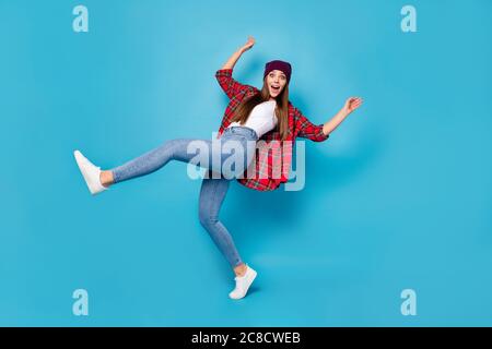 Foto profilo a lunghezza intera di buon umore bella signora caldo primavera tempo gioire alzate gamba camminare strada eccitato indossare casual jeans per camicia con cappello Foto Stock