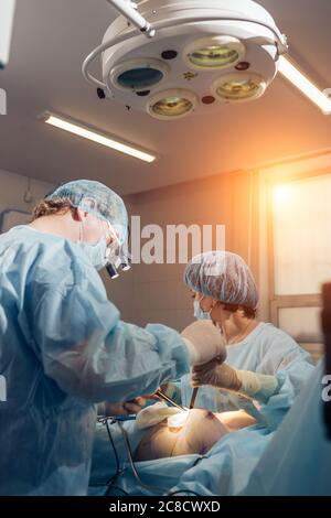 Il team di chirurgia operanti in una sala chirurgica Foto Stock