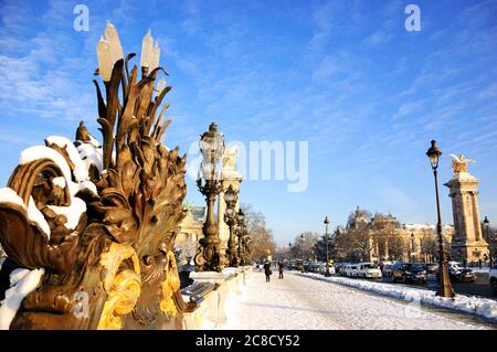 Parigi sotto la neve. Vista sul ponte Alexandre III. Gli edifici del Grand Palais e del Petit Palais sullo sfondo. Foto Stock