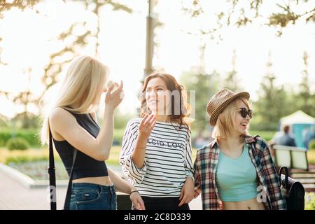 Ritratto di tre giovani amici che camminano nel parco. Giovani donne che passeggiano in una giornata estiva. Foto Stock