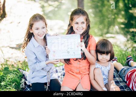 Felici i bambini che fanno arte e artigianato insieme nel parco Foto Stock