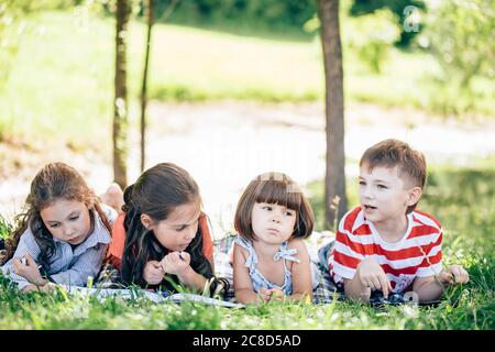 Gruppo di dipinti per bambini al easel in parco Foto Stock