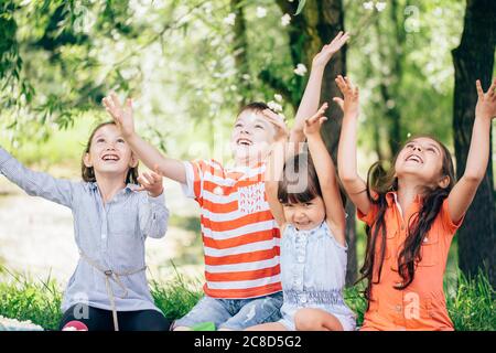 I bambini felici si divertono con il pop corn e le bevande mentre si siedono sul divano Foto Stock