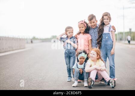 Grande gruppo multiculturale di bambini felici che guardano nella telecamera. Esterno. Il concetto di amicizia e comunicazione interculturale Foto Stock