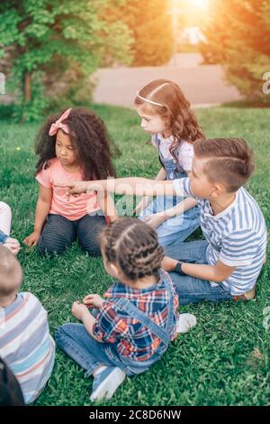 Bambini felici che giocano nel Parco in estate. Gruppo multiculturale: Il concetto di infanzia, amicizia e comunicazione interculturale. Foto Stock