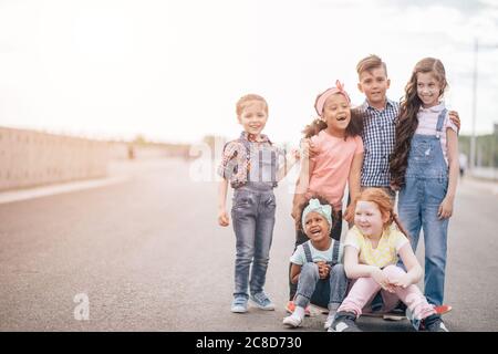 Grande gruppo multiculturale di bambini felici che guardano nella telecamera. Esterno. Il concetto di amicizia e comunicazione interculturale Foto Stock