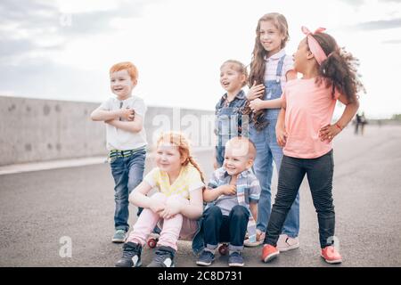 felici i bambini di diverse culture che si divertono insieme, giocando, parlando, ridendo, il concetto di amicizia e comunicazione interculturale Foto Stock