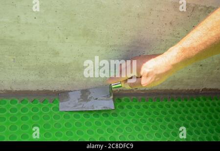 spalmare i pavimenti con colla con cazzuola intagliata Foto Stock