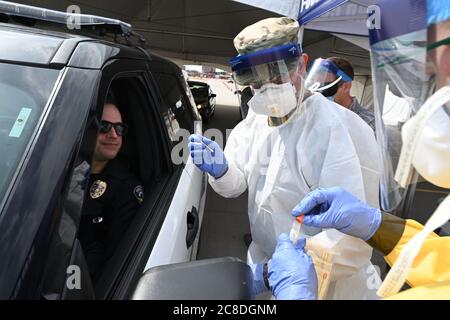 Il Lt. Colon. Dwight Harley, del 119esimo Medical Group, preleva un campione di tampone da un agente di polizia Fargo asintomatico che si sta volontariamente facendo un test COVID-19 nel parcheggio del FaroDome, N.D., 25 aprile 2020. Indossa dispositivi di protezione individuale (DPI) per rimanere al sicuro mentre lavora e contribuire a prevenire la diffusione del Coronavirus mentre testa le persone mentre guidano attraverso il processo di test di massa nei loro veicoli. È solo uno dei tanti N.D. Membri della Guardia Nazionale in collaborazione con IL N.D. Dipartimento della Sanità e di altre agenzie civili a sostegno della risposta comunitaria Foto Stock