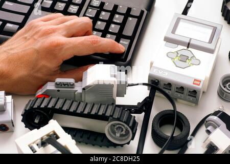 Tambov, Federazione Russa - 25 Dicembre 2019 persona mano sulla tastiera codifica LEGO MINDSTORMS blocchi robot EV3 sul computer. Scatto in studio. Foto Stock