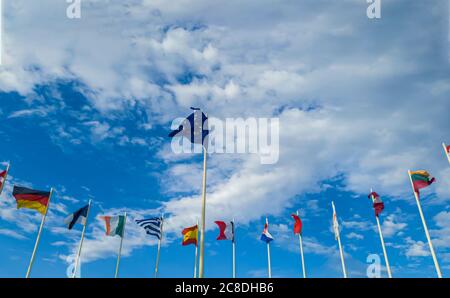 Bandiere dei paesi europei sui pali di luce contro un cielo nuvoloso Foto Stock