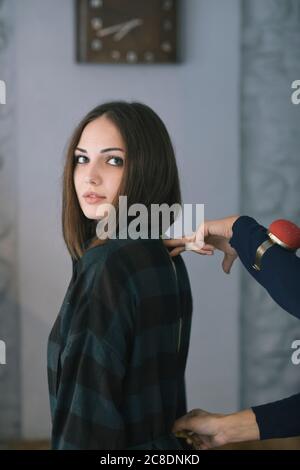 Mani tagliate di misura su misura della schiena di una giovane donna nel design studio Foto Stock