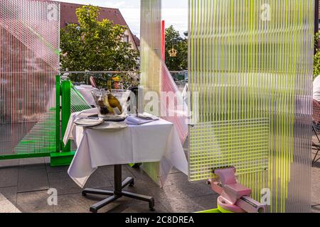 Catering esterno con pareti divisorie disegnate artisticamente e camerieri con maschere protettive in Hotel Krone a Weil am Rhein, Germania Foto Stock