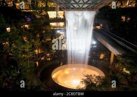 SINGAPORE - 3 MARZO 2020: Cascata al GIOIELLO del centro commerciale al terminal 4 dell'aeroporto changi di singapore in serata. Spettacolo di luci sull'acqua Foto Stock