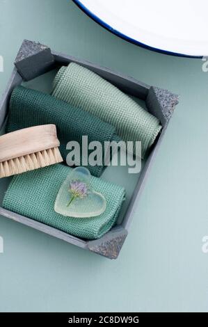 Spazzola per unghie, asciugamani e colate di erba cipollina in una barra a forma di cuore di sapone di glicerina Foto Stock