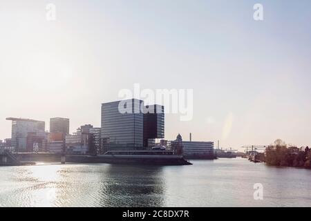 Germania, Nord Reno-Westfalia, Dusseldorf, Sole che splende su Media Harbour con Stadttor sullo sfondo Foto Stock