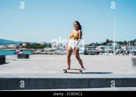 Skateboarder femminile al porto Foto Stock