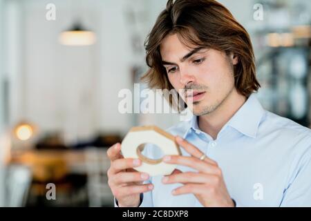 Primo piano di un uomo d'affari attento che guarda l'oggetto nel caffè Foto Stock