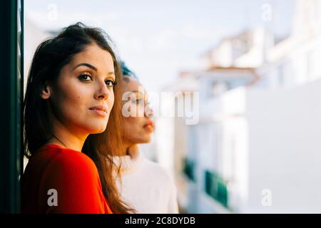 Le donne che si guardano mentre si levano in piedi in balcone Foto Stock
