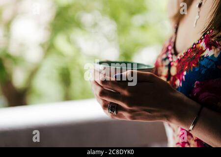 Primo piano delle mani della donna che tengono la tazza di caffè