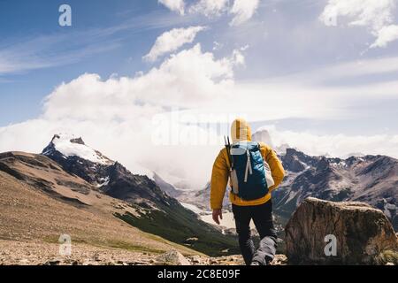 Uomo con zaino che cammina sulla montagna contro il cielo durante l'inverno, Patagonia, Argentina Foto Stock