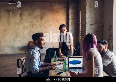 Persone creative che lavorano al tavolo in un ufficio loft Foto Stock