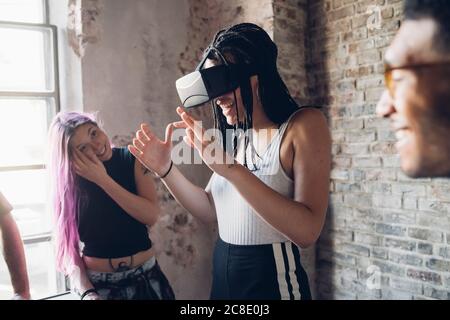 Un team creativo felice che utilizza gli occhiali VR in un ufficio loft Foto Stock