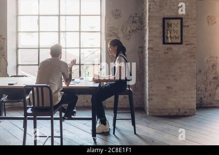Due persone creative che hanno una riunione in un ufficio loft Foto Stock